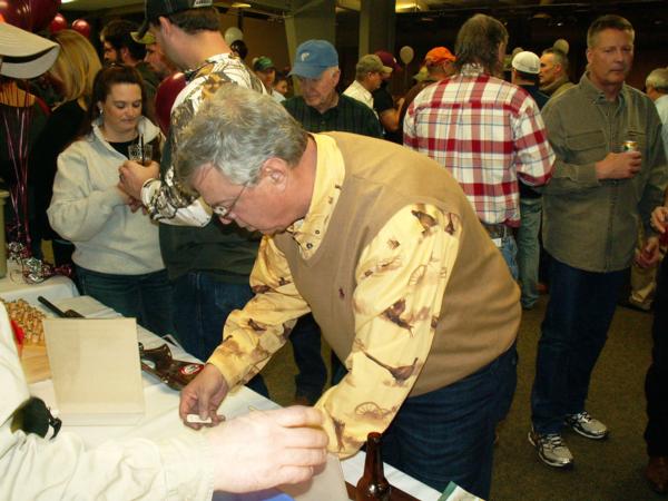 An attendee purchases a raffle ticket at the 2015 PF Banquet